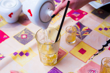 makes tea with boiling water from a teapot