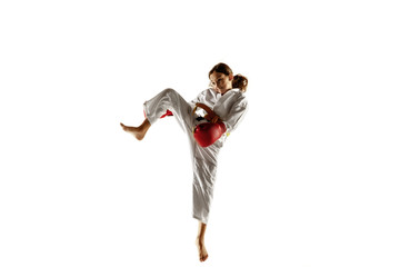 Confident junior in kimono practicing hand-to-hand combat, martial arts. Young female fighter with...