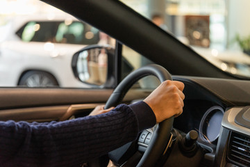 Hands on the steering wheel of a luxury car