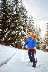 Winter climb to the top of the mountain with a backpack.