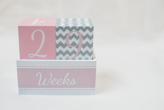 Rosa grauer Wochenwürfel 29 Wochen 29 weeks vor weißem Hintergrund - Powered by Adobe