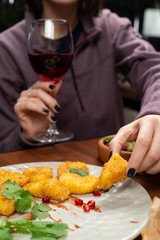 Woman eating deep fried cheese nuggets with hands