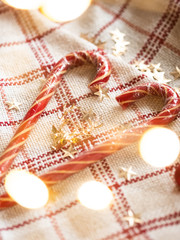 Candy Canes in the shape of a heart. Cozy new year. Christmas card with christmas lights and decorations. Selective focus. Christmas background. Valentine's Day