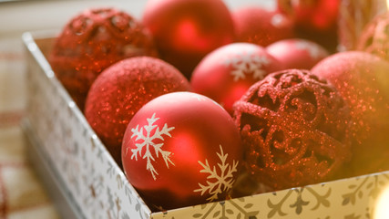 Abstract christmas background. Red Christmas tree toys in a box, preparation for decorating a Christmas tree. Christmas card with Selective focus.