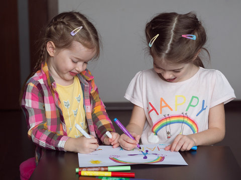 Happy cute kids draw rainbows and write the word  happiness