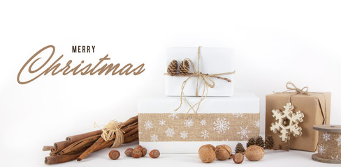 Schriftzug "Merry Christmas" und verpackte Geschenke als Weihachtskarte oder Gutschein