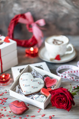 Cookies or gingerbread cookies in a gift box with a red ribbon on a wooden table. Valentine's Day.