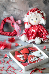 Cookies or gingerbread cookies in a gift box with a red ribbon on a wooden table. Valentine's Day.