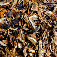 many dried mushrooms lies on a white wood desk