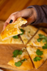 Woman is eating ossetian pies with cheese with hands in a cafe