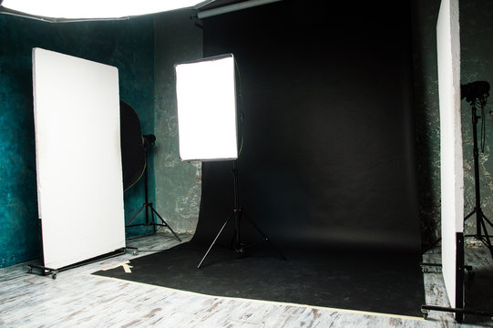 The interior of the photo studio. Preparing to work with photographic equipment. Black cyclorama, exposure to light on the octobox, softbox. Studio flags.