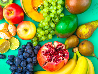 Fruits and vegetables rich in antioxidants, vitamin and fiber on trendy mint green background. Raw, vegan, vegetarian, alkaline food concept. Flat lay style. Close up