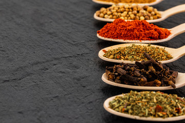 Various spices on dark background, with copy space.