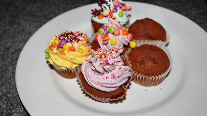 Close up view of various sweet cupcakes, selectively focused, against a bokeh background