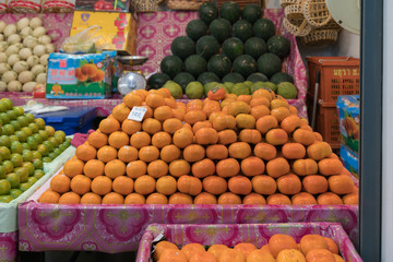 Persimmons on a fruit stand in a Thai food market