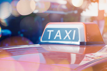 Taxi sign on top of the car with copy space with bokeh light flare.
