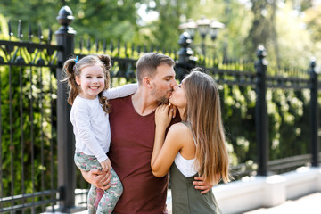 Young family with daughter have fun outside in the park.