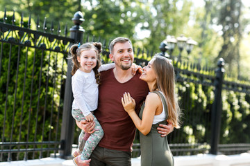 Fototapeta premium Young family with daughter have fun outside in the park.