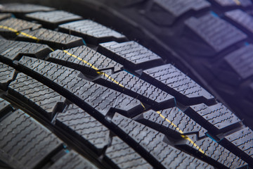 Protector close-up of new winter tires. on black background