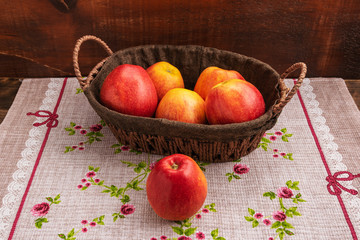 A basket of apples stands on a cloth napkin.