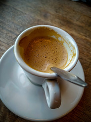 White small cup and plate of espresso coffee served in a restaurant during a break with warm delicious beverage