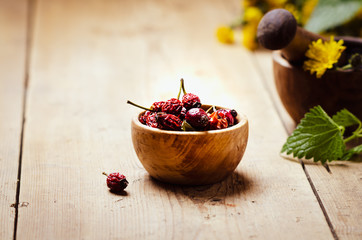  Dried rose hip for herbal tea in a wooden bowl. 