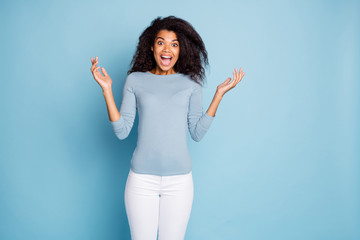 Photo of curly wavy cheerful nice pretty brown haired girlfriend shouting in white trousers hearing unbelievably good news isolated over blue pastel color background