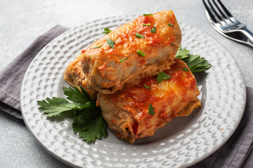 Cabbage rolls with beef, rice and vegetables on the plate. Stuffed cabbage leaves with meat. Gray concrete table
