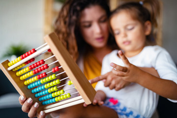 Mother and little cute girl, kid playing with abacus, early education