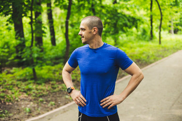 Athletic man looking away standing in the park or forest