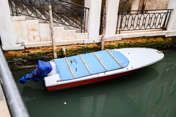 Fototapeta na wymiar 09.10.2019 Venice, Italy, City canal with moored motor boats and gondola.