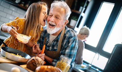 Grandfather and his grandchildren spendig happy fun time in kitchen