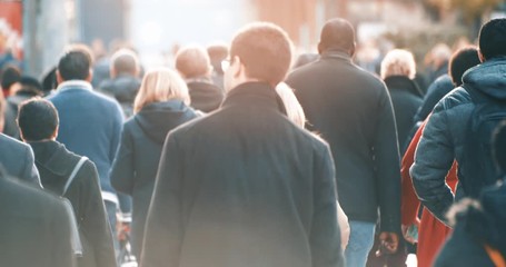 Commuters walking to work with morning sun light in business district, footage of blurred people commuting in downtown from back, busy city life, 4K video - Powered by Adobe
