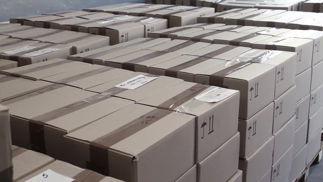 Boxes with products stacked in stock, ready to be sent for sale. Paper boxes in stock, closeup. Warehouse space. Products on the warehouse stacked in large piles in cardboard boxes, close-up.
