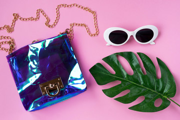 Beach handbag and glasses. Trendy summer concept. Pink background.