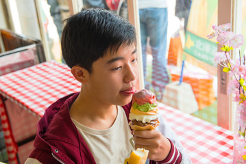 A happy young man to eat ice cream in a café shop