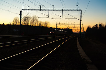 Obraz na płótnie Canvas Kouvola, Finland - 15 November 2019: Train and railway at beautiful sunset background.