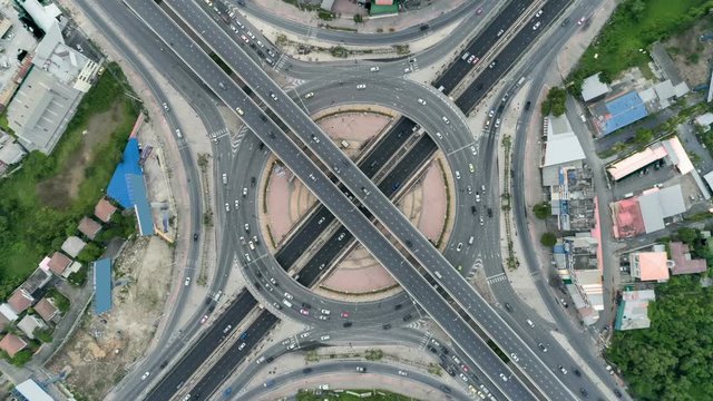 timelapse of day city traffic on 4-way stop street intersection circle roundabout in bangkok, thailand. 4K UHD horizontal aerial view.