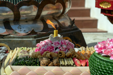 Candle and offerings at Wat Ming Mueang, Chiang Rai, Thailand