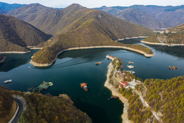 Blue vucha dam in Rhodope mountains during a colorful autumn with some blue clouds in the skies