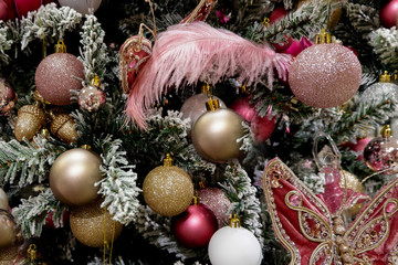 Vintage Christmas tree decorated with various pink, whote and gold toys and bubbles. Festive background