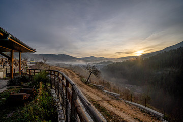 Sunrise in a hidden mountain village with fog between the houses and the trees