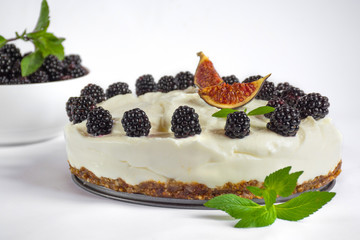 Raw vegan cashew nutty coconut cheesecake with blackberry and mint isolated on white background,...