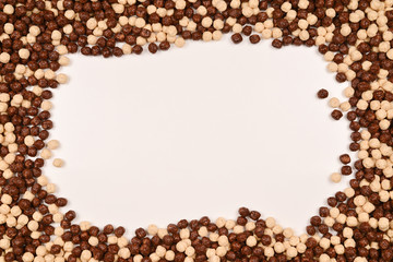 Frame of chocolate corn flakes  isolated on white background.