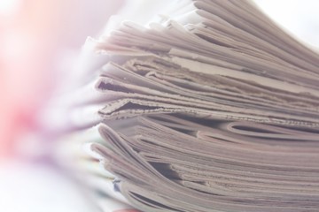 Stack of newspapers close up background, soft light