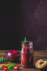 Homemade DIY natural canned hot plum sauce chutney with chilli or tkemali in glass jar