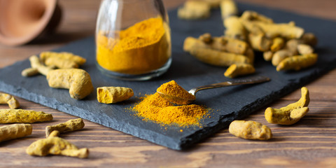 Turmeric powder and roots, healthy healing spice, commonly used in Indian and Asian cuisine