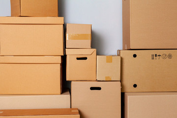 Fototapeta premium Cardboard boxes for moving on the floor against grey wall