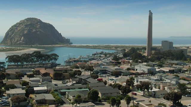Aerial flying over the beach town of Morro Bay, powerplant &  Morrow Rock in California, USA. 18 April 2019