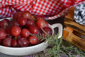 Red grapes with water drops in white plate